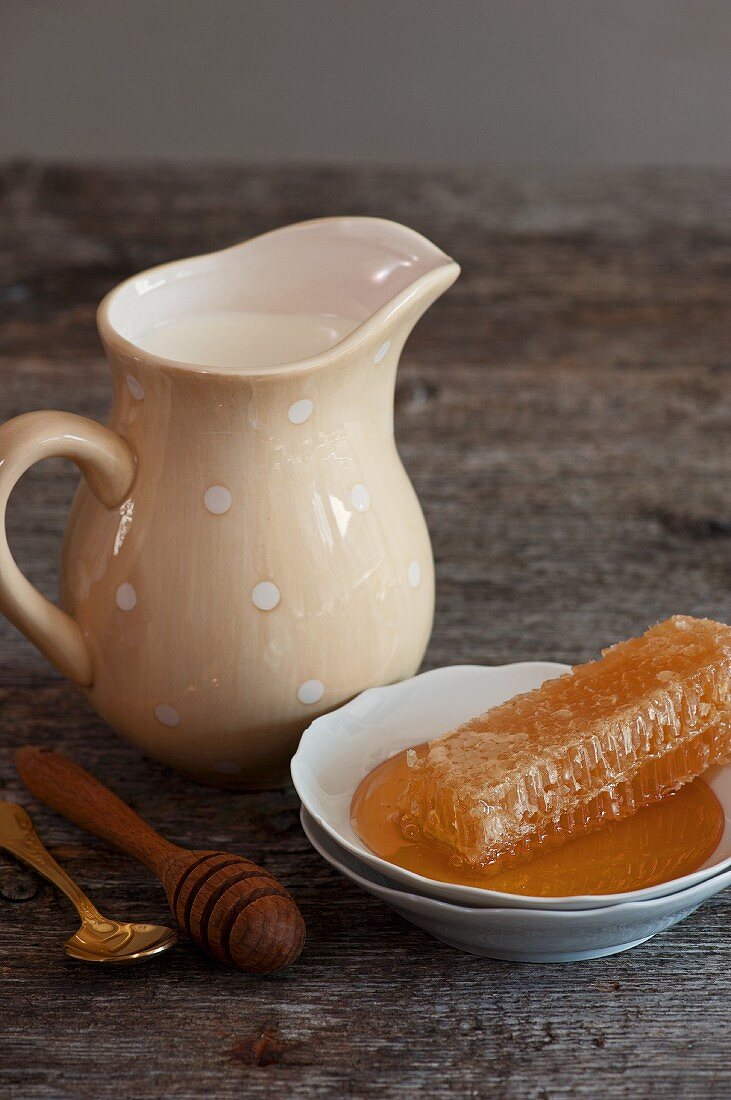 Milk in a porcelain jug and a honeycomb