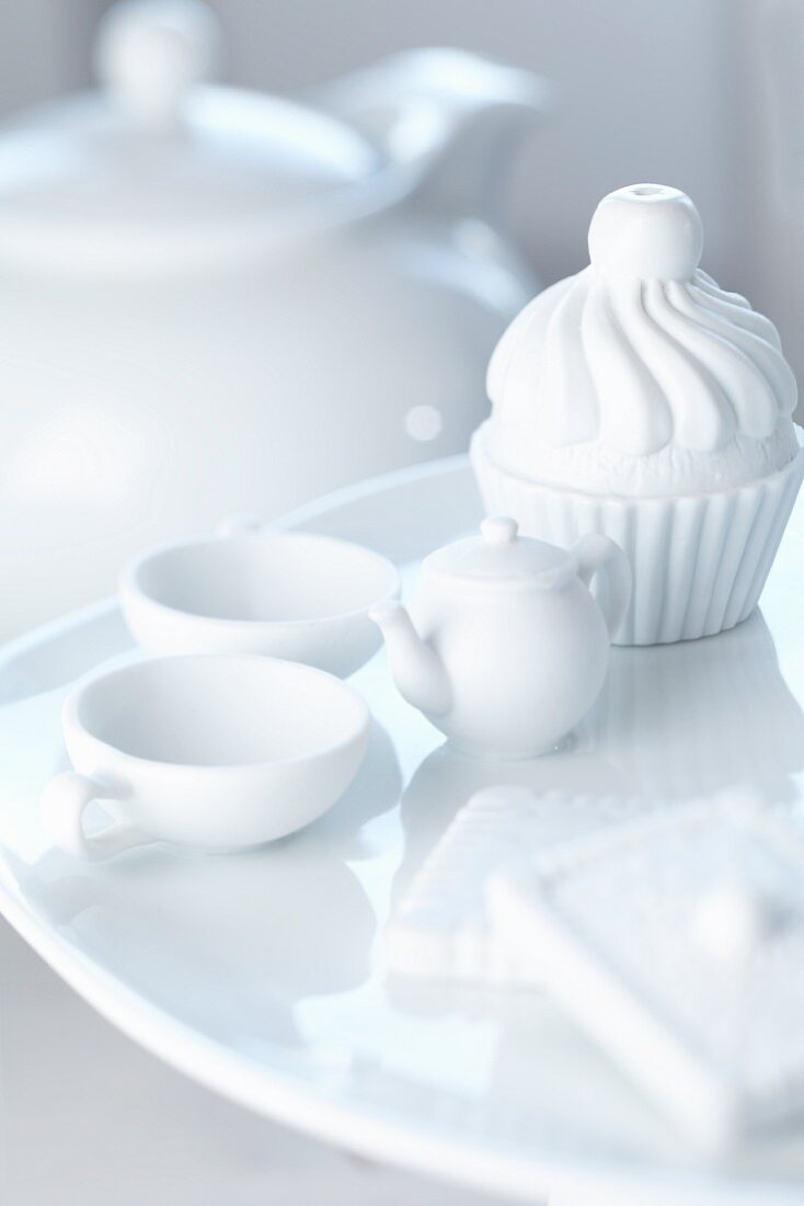 A mini teaset and cupcake made of porcelain
