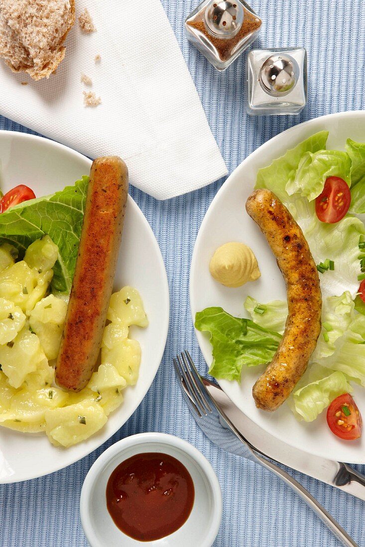 Bratwurst with potato salad and vegetarian sausage with salad
