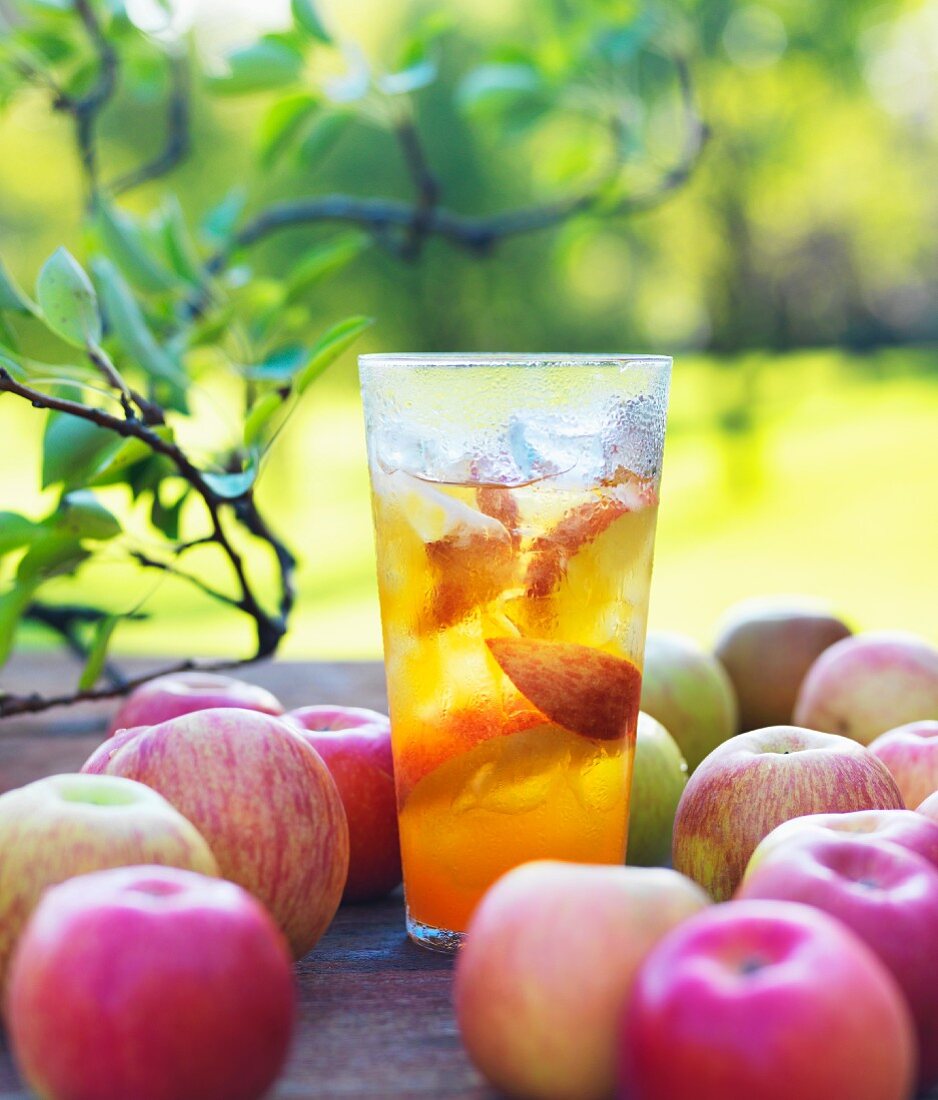 Ein Glas Bio-Apfelsaft aus Fuji Äpfeln auf Gartentisch