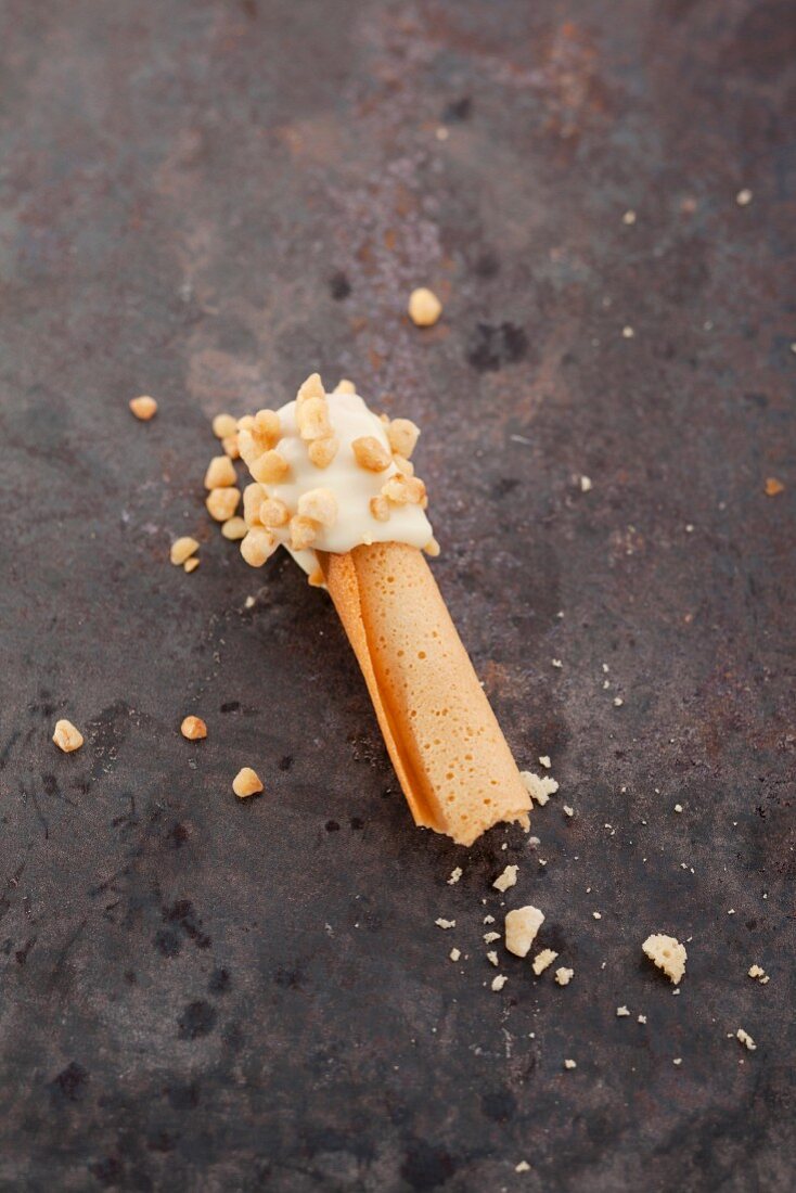 Rolled wafers dipped in white chocolate and chopped nuts
