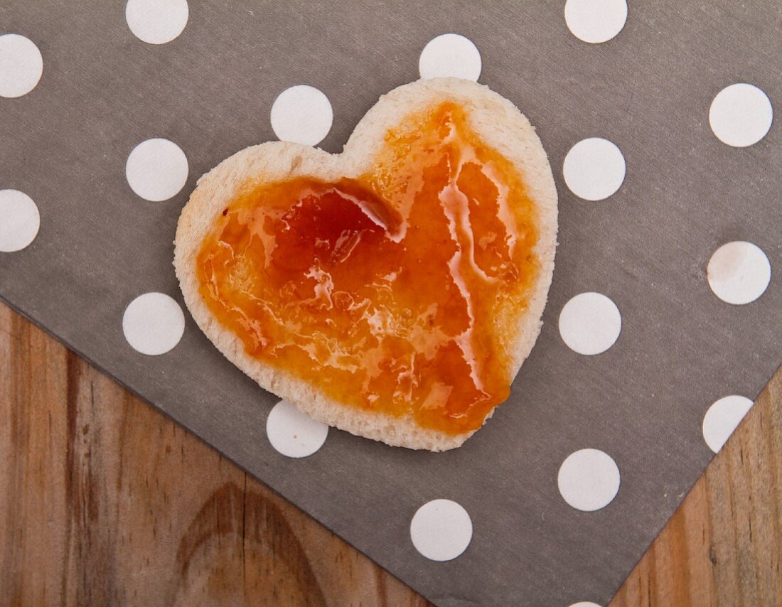 A heart cut out of bread, topped with jam, for Valentine's Day