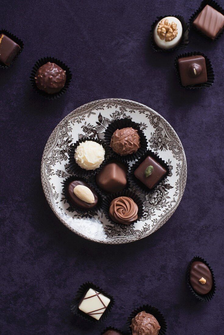 An assortment of filled chocolates, some on a plate