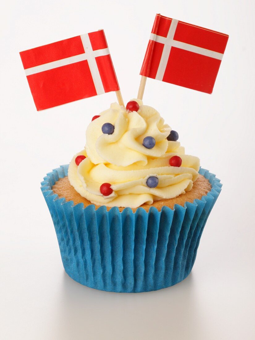 A cupcake decorated with buttercream and Danish flags