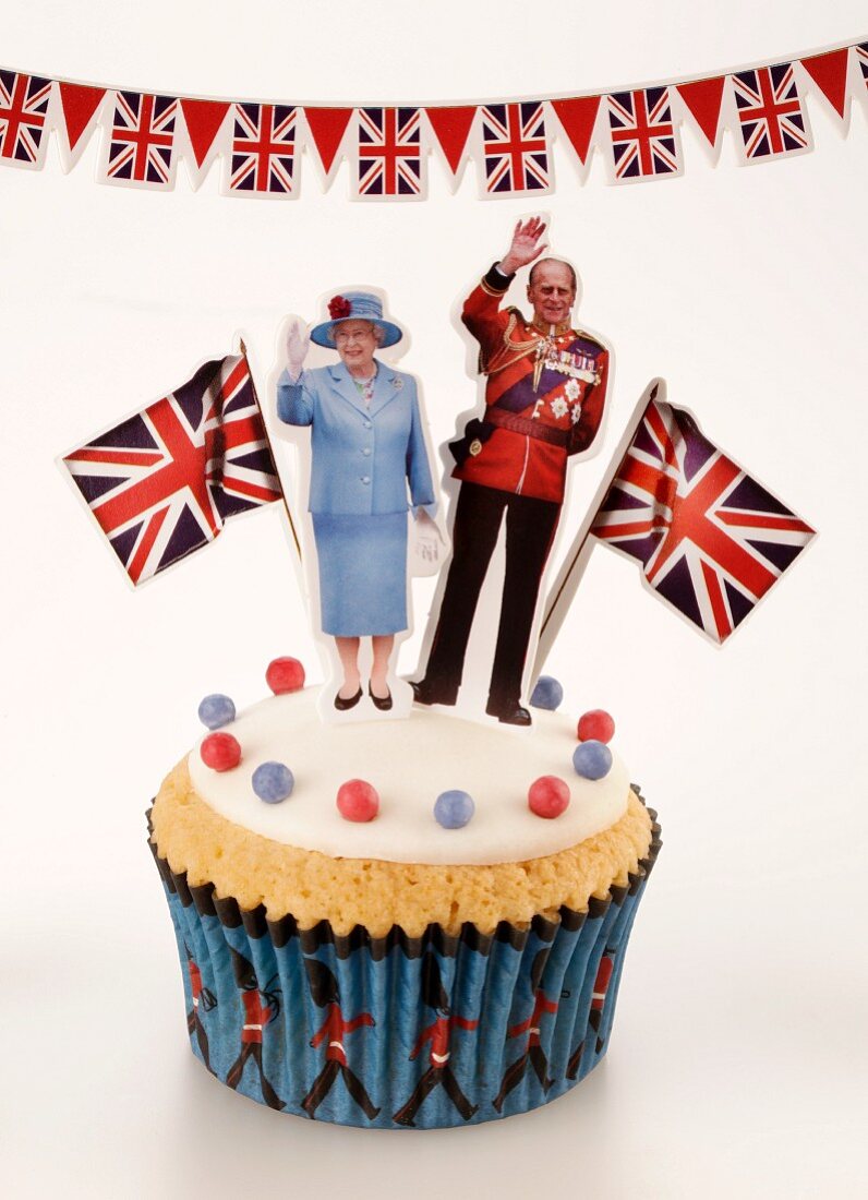 A cupcake topped with Queen Elizabeth II of England and the Duke of Edinburgh