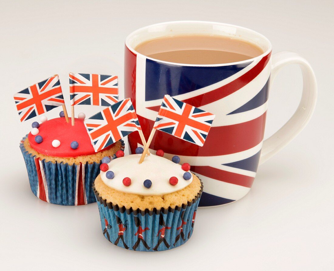 Cupcakes decorated with Union Jack flags, and a cup of tea