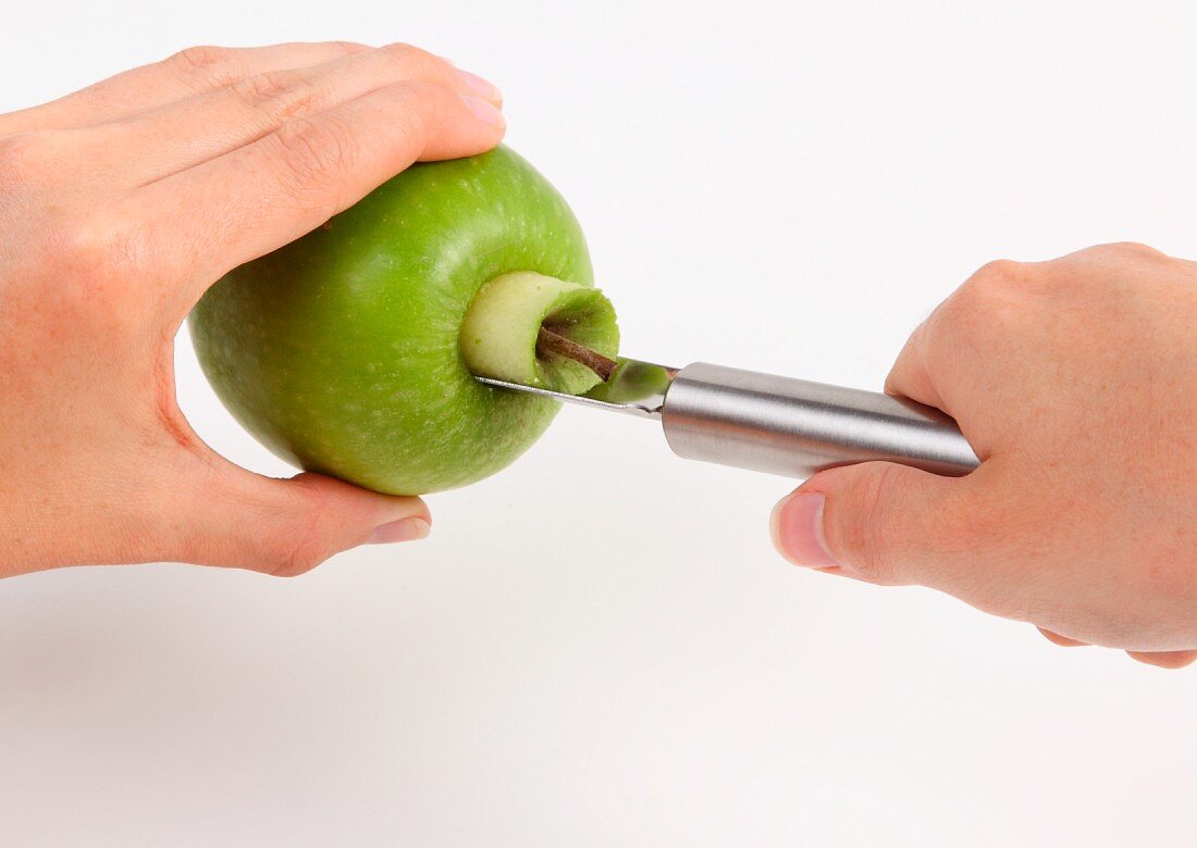 Kerngehäuse von einem grünen Apfel ausstechen