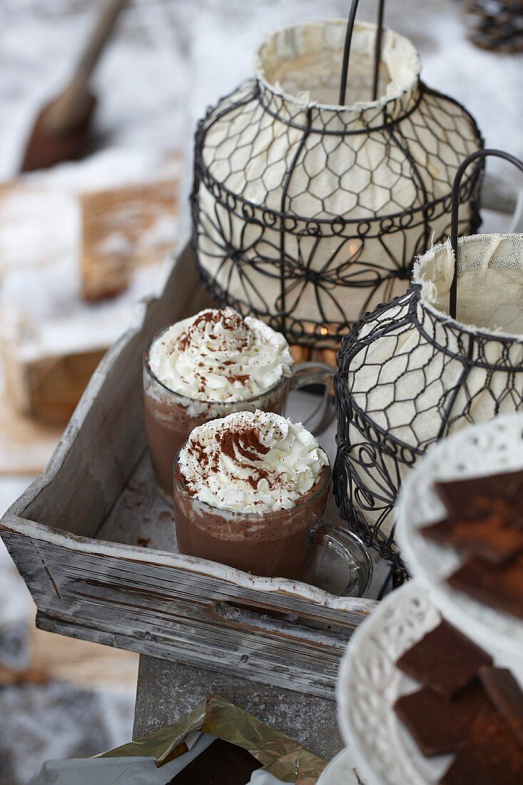 Glasses of hot chocolate and lanterns on a wooden tray