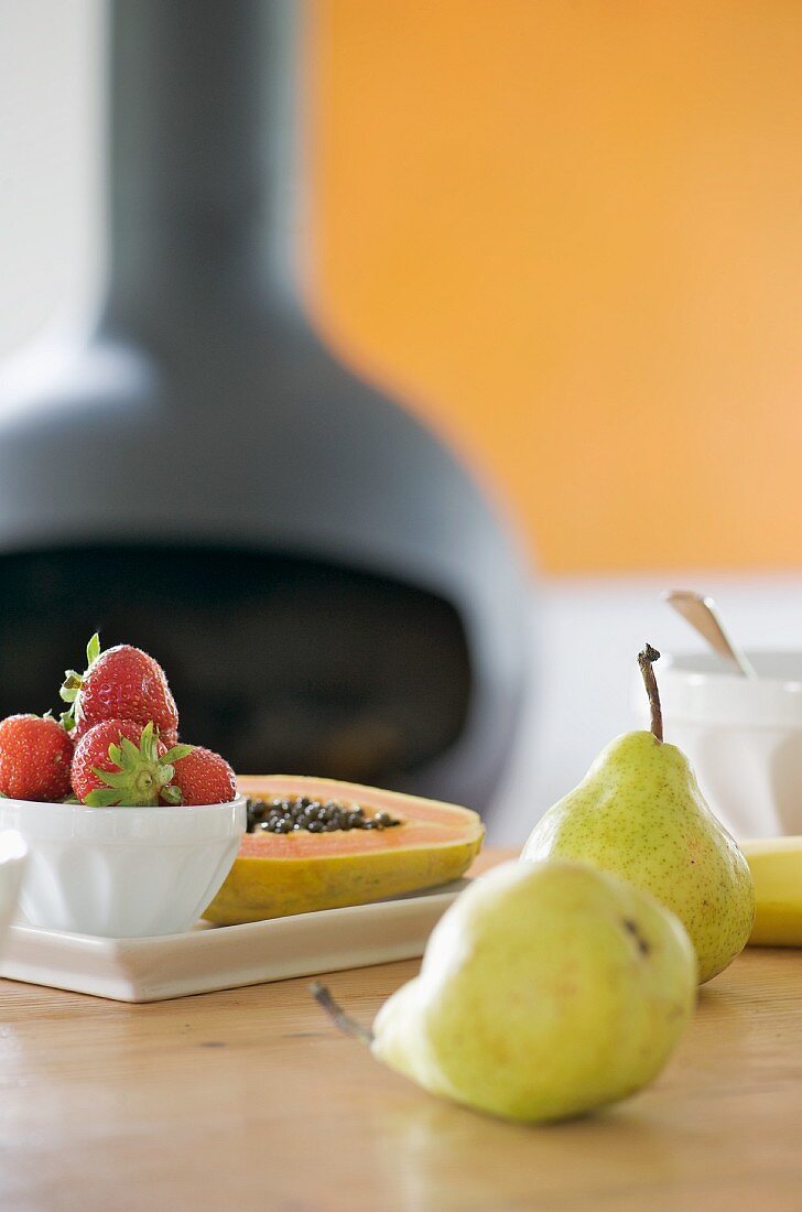 Frisches Obst auf Tisch und Kanonenofen im Hintergrund