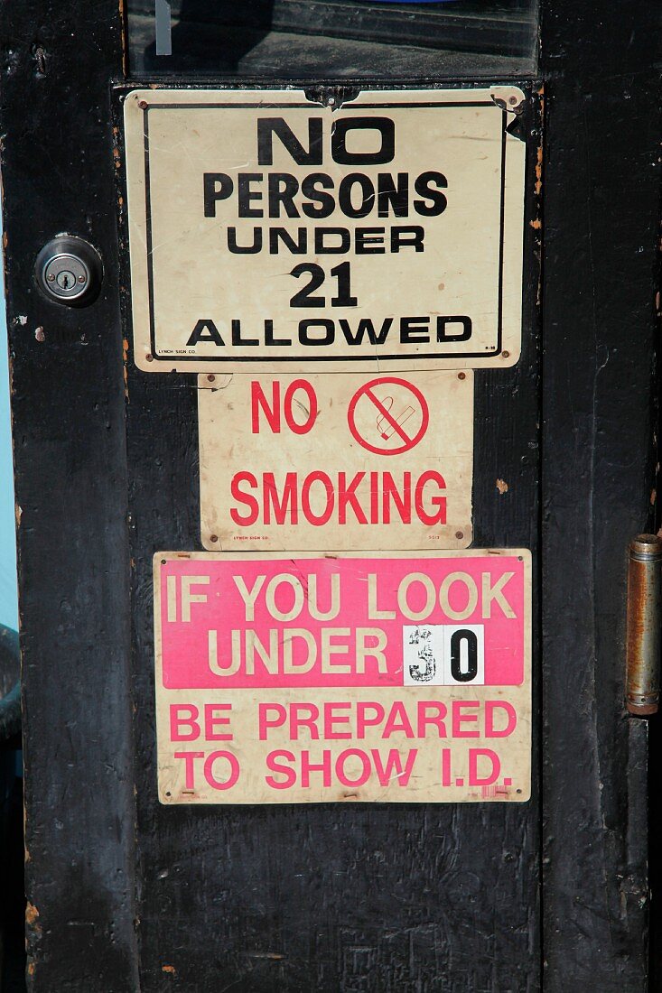 Schilder an der Eingangstür einer Bar (USA)