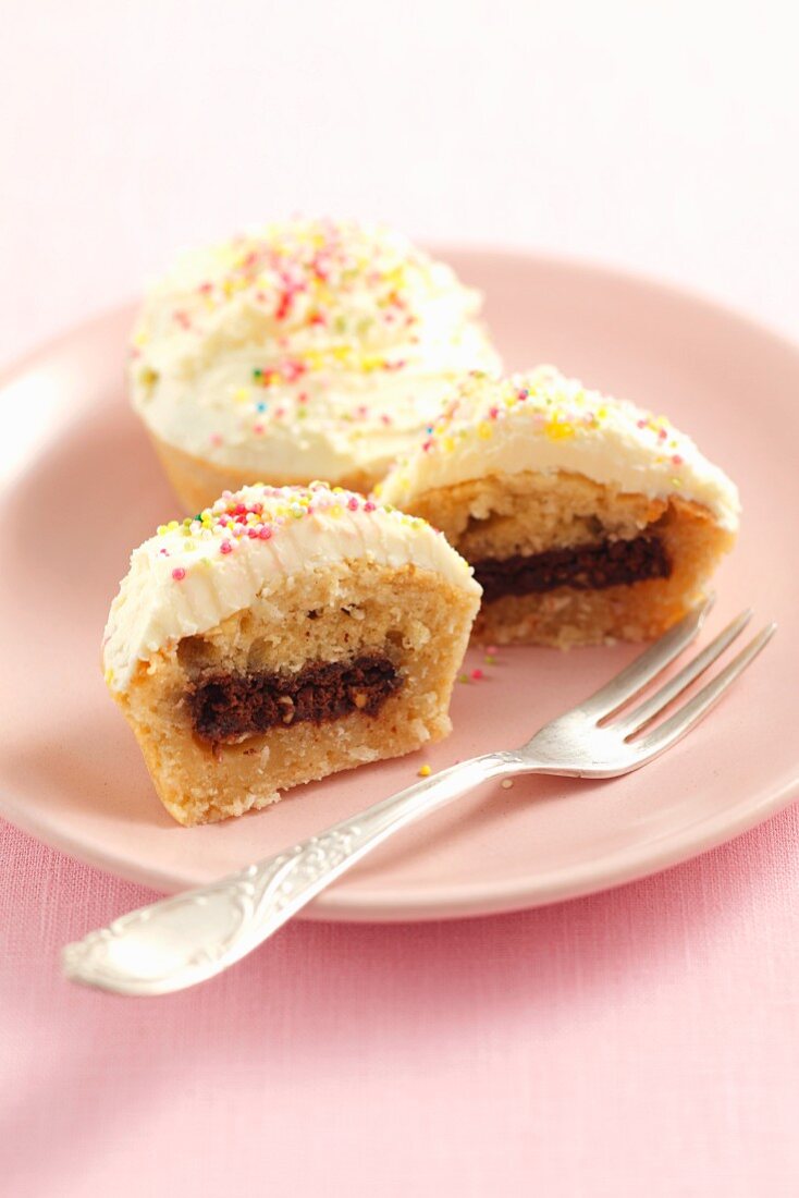 Coconut cupcakes filled with chocolate wafer and topped with mascarpone and lemon cream