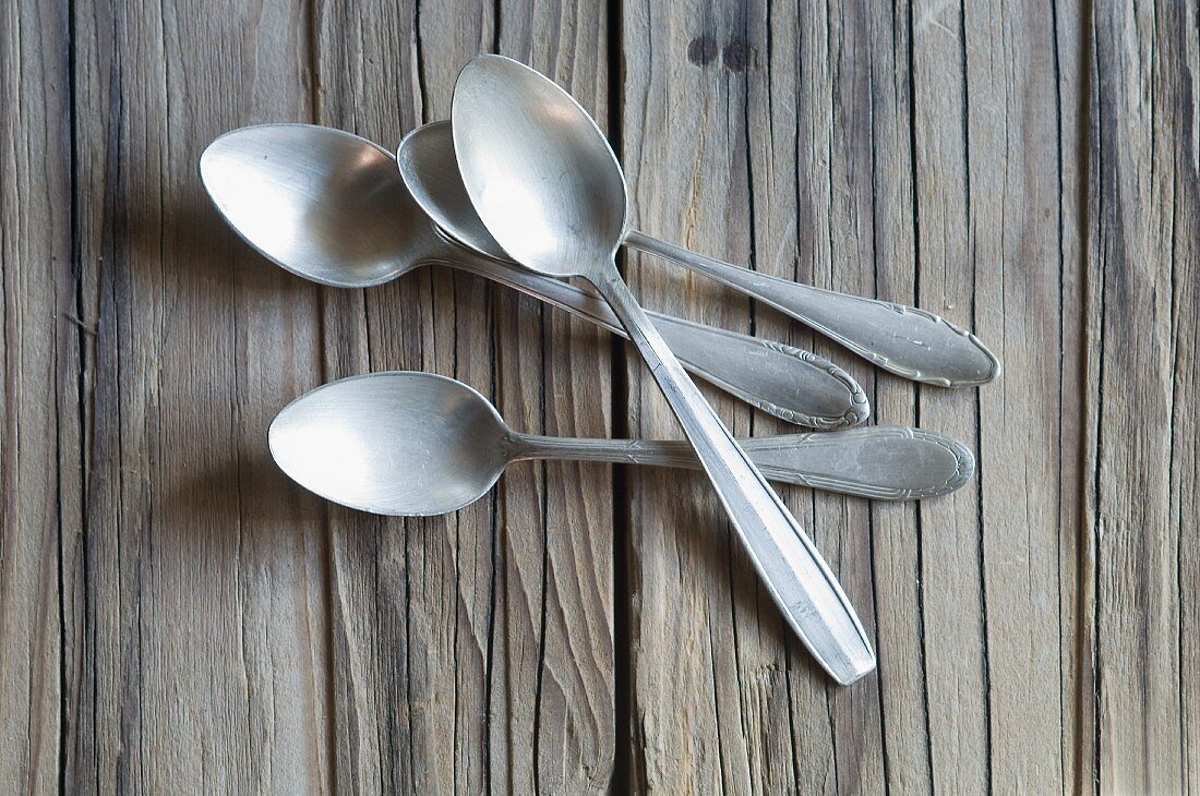 Several teaspoons on a wooden surface