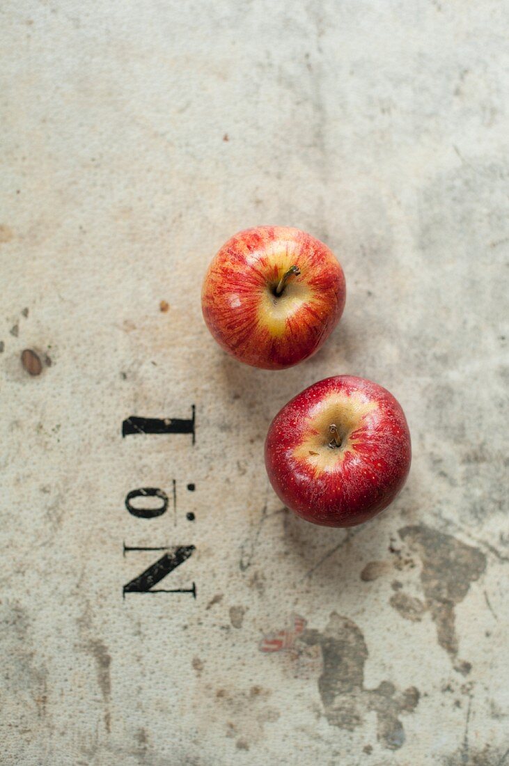 Two red apples next to a printed 'No. 1'