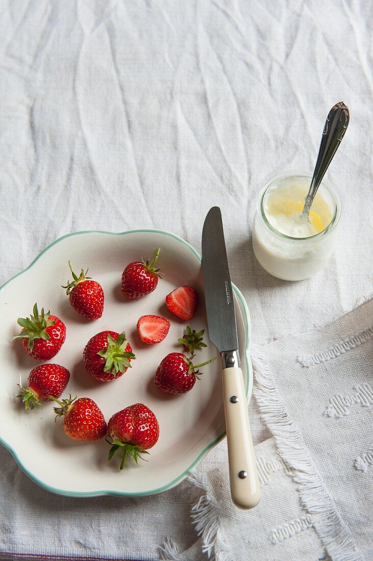 Fresh strawberries and a jar of natural yoghurt