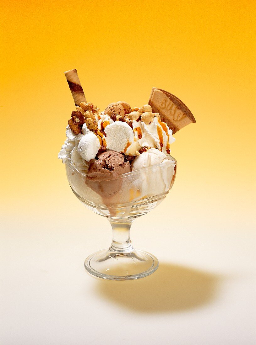 A nut sundae with vanilla and nut ice creams, cream, amarettini biscuits, wafers, nuts, meringues and butterscotch sauce
