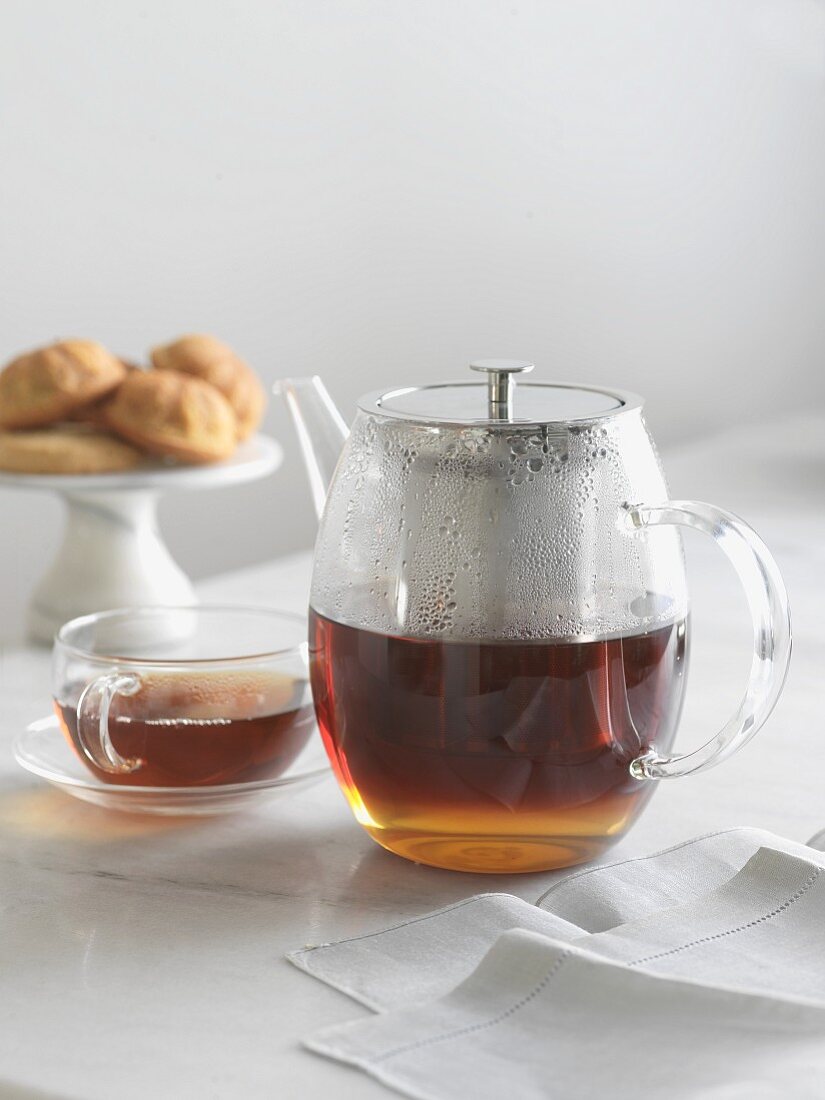 Clear Glass Tea Pot with Tea; Cup of Tea and Gluten Free Cakes