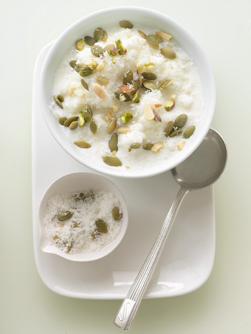 Bowl of Rice Pudding Topped with Coconut and Pumpkin Seeds