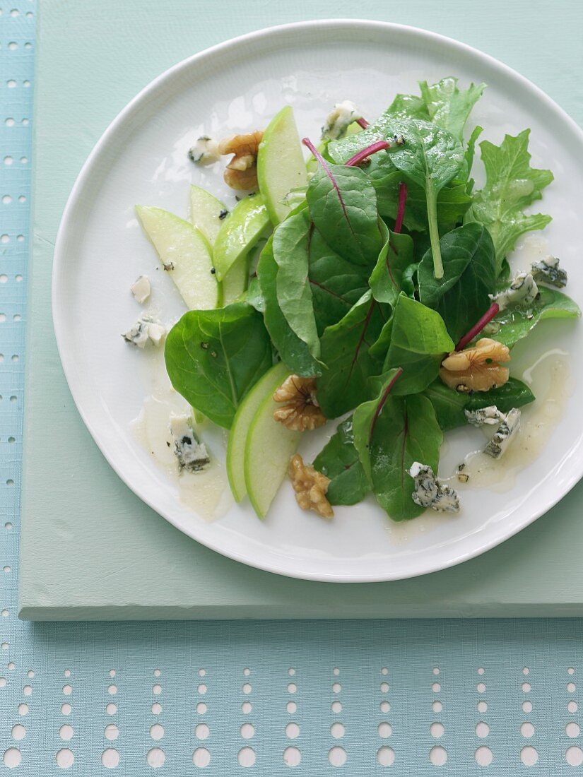 Mixed Green Salad with Apple, Walnuts and Blue Cheese; On a White Plate