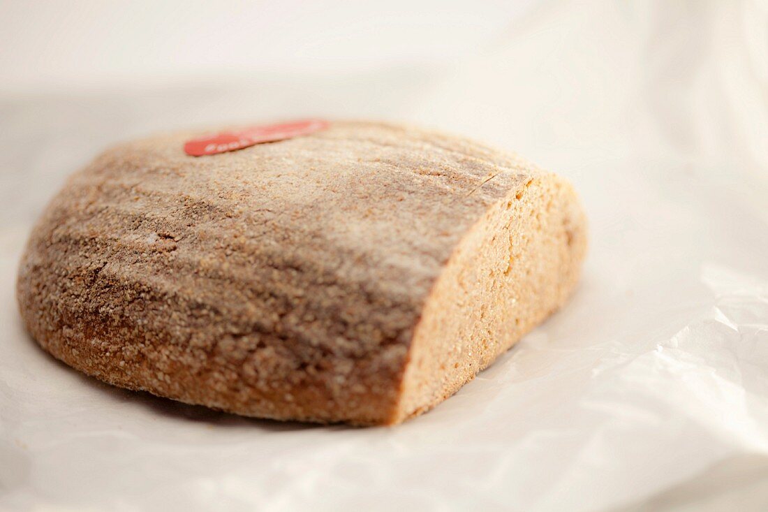 A loaf of bread, cut, with flour