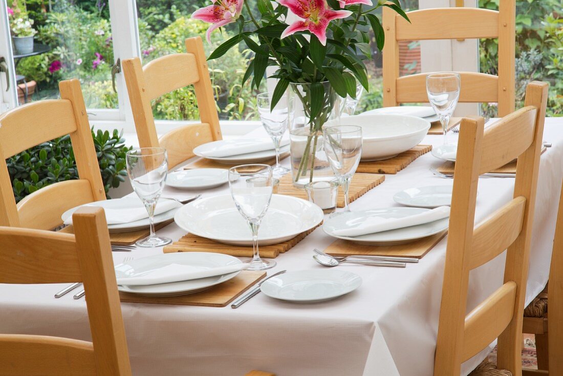 A table laid for a meal in a well-lit room by the window