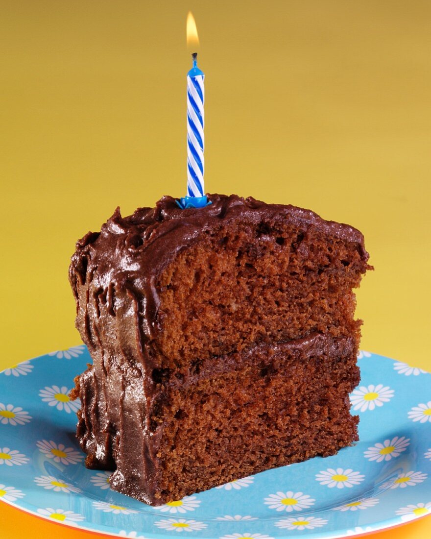 Ein Stück Devils Food Cake (Schokoladentorte, USA) mit Geburtstagskerze
