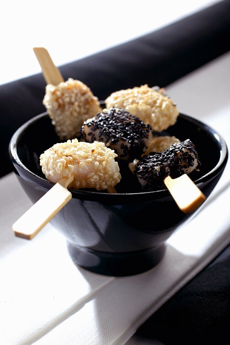 Fish skewers with black and white sesame seeds