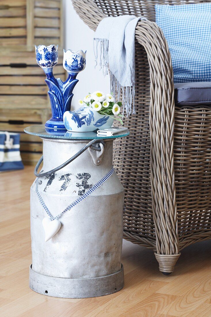 Dutch-style ornaments on milk churn converted into side table and wicker chair with scatter cushions