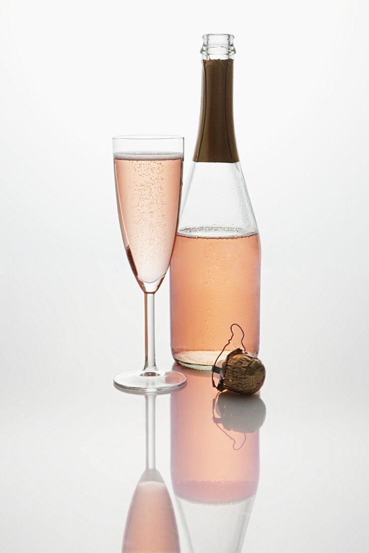 Pink sparkling wine (bottle, champagne glass and cork)