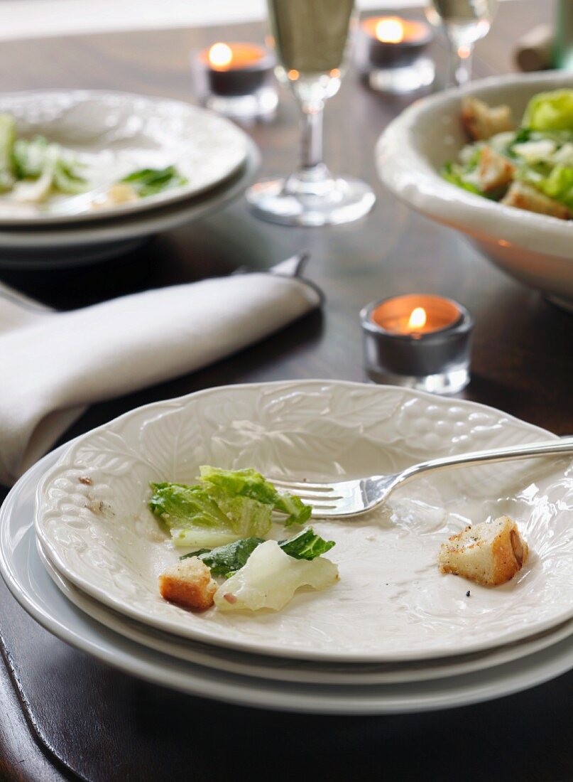 Essensreste eines Caesar Salad auf leergegessenem Teller