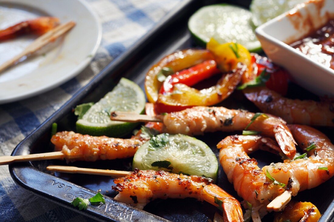 Grilled Shrimp with Toothpicks on a Baking Pan with Lime and Cocktail Sauce