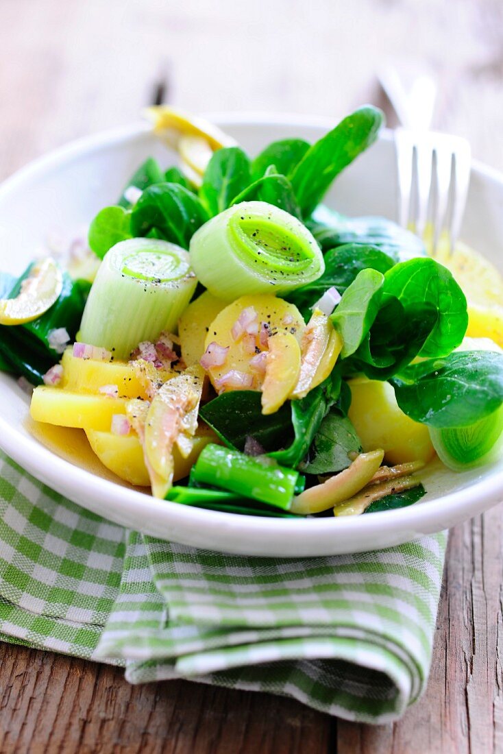 A salad of potatoes, lamb's lettuce, leek and red onions