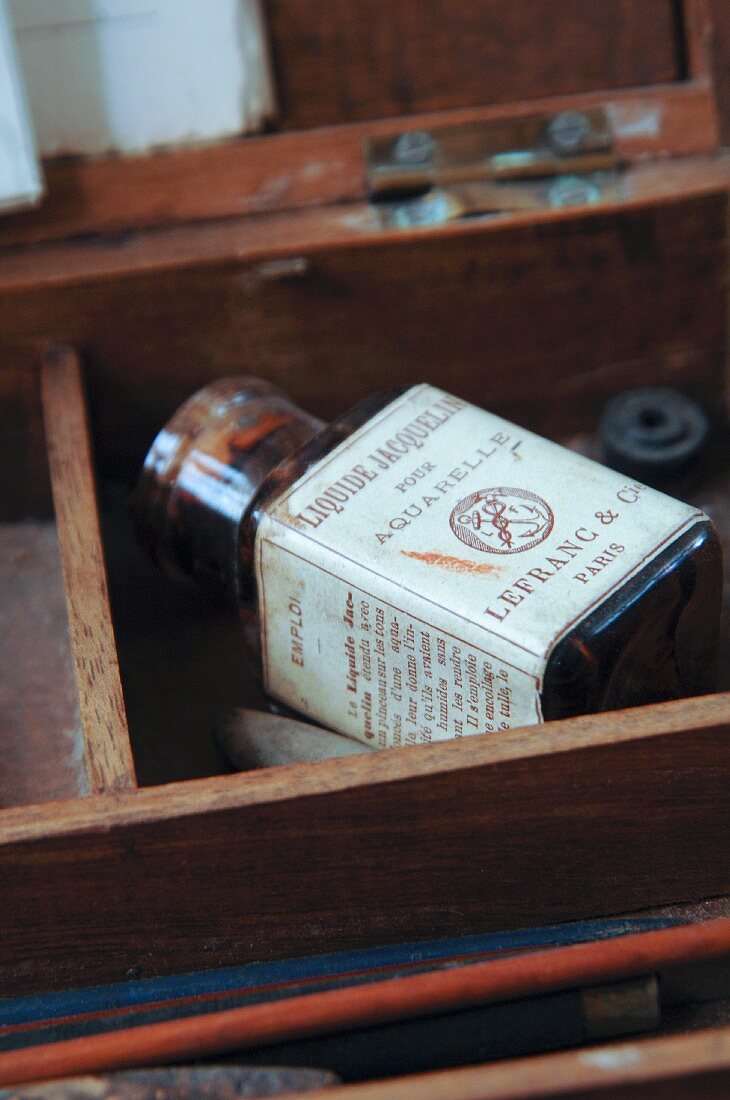 Old bottle of water colour paint with French label in wooden box