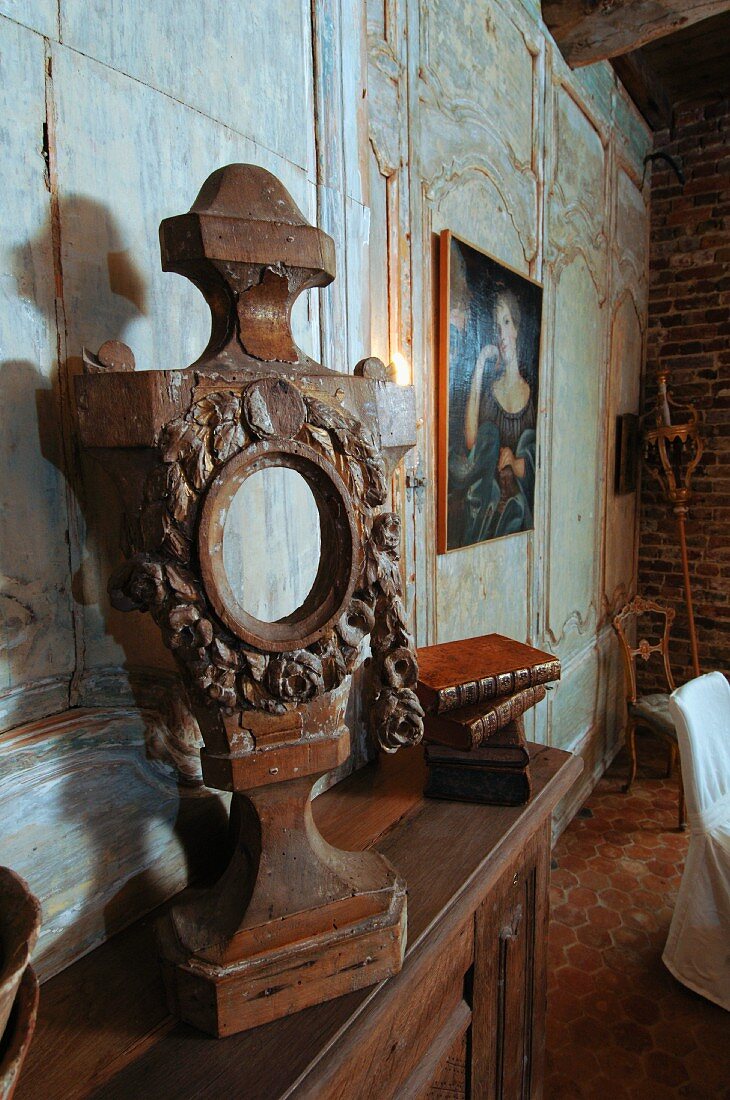 Vintage wooden figure on shelf against wall with faded wooden panels in living room