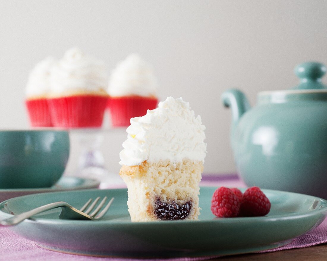 Halber Cupcake mit Himbeerfüllung und Frosting