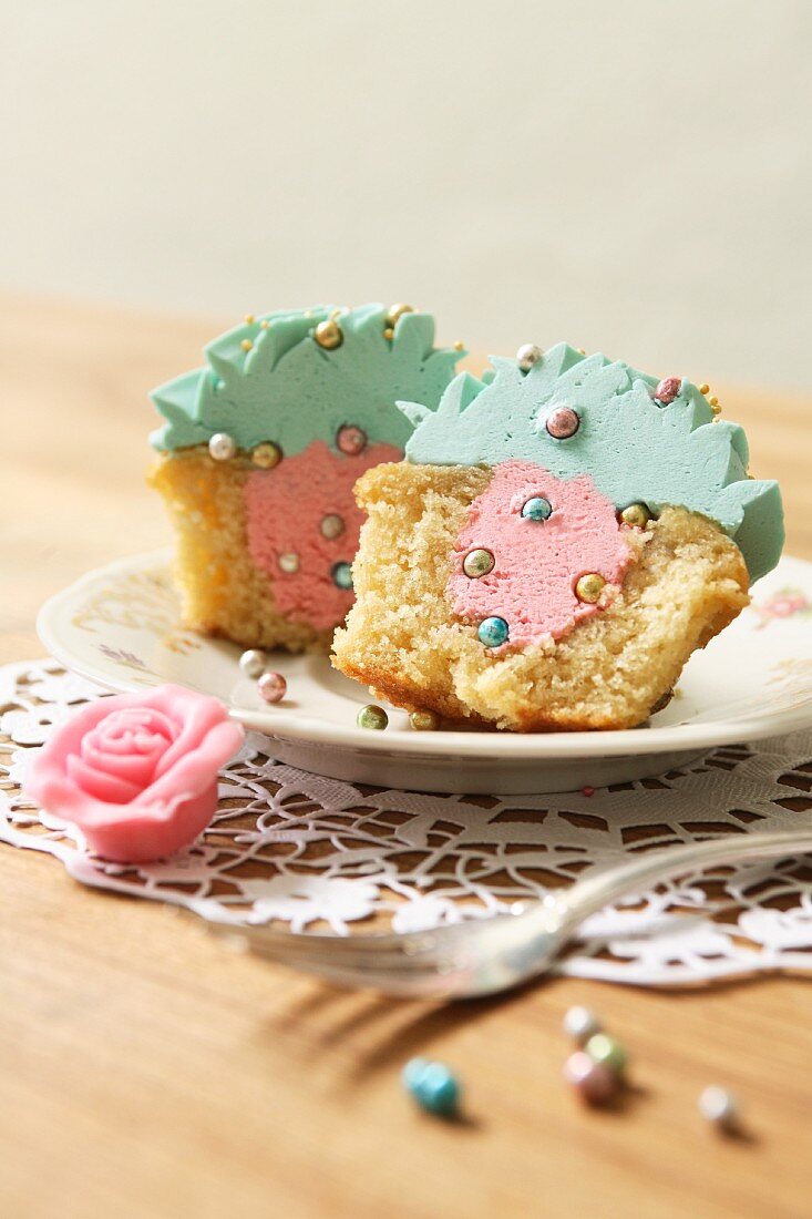 Gefüllter Cupcake mit Erdbeer-Butter-Creme und türkisfarbenem Topping