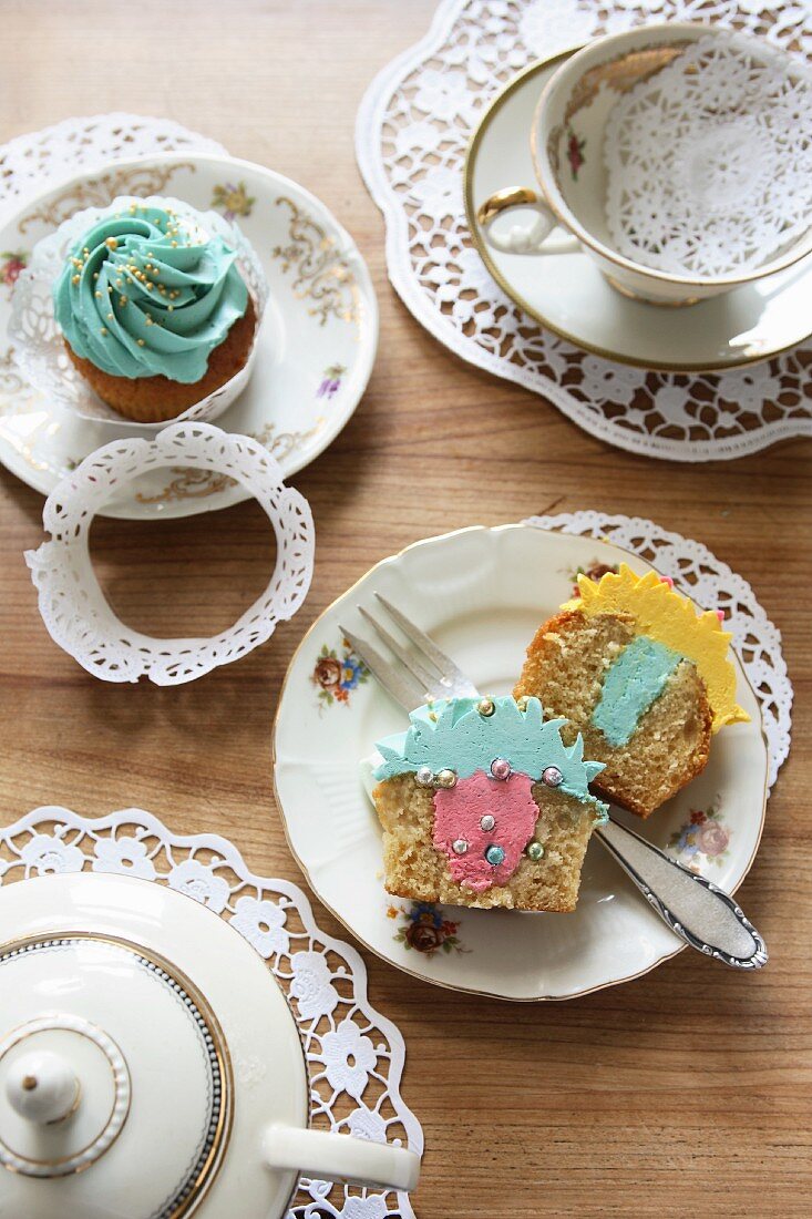 Tea crockery and cupcakes filled with buttercream