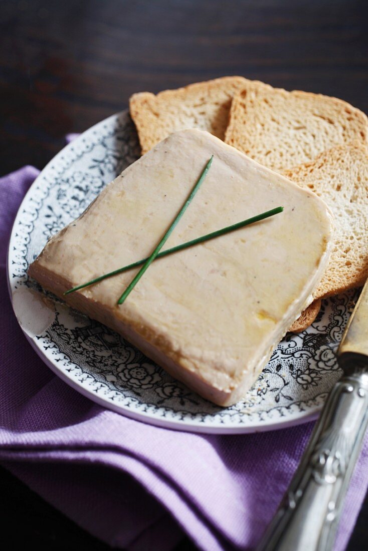 A slice of foie gras with toasted bread slices