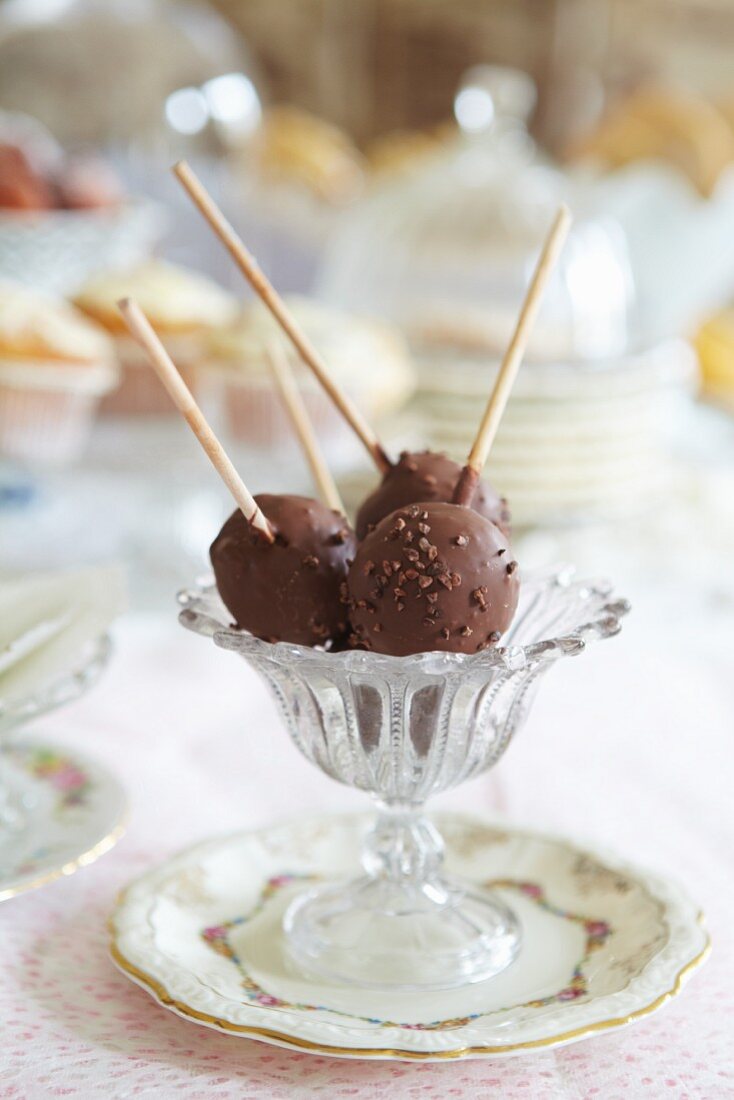 Chocolate lollies with chopped nuts in a dessert glass