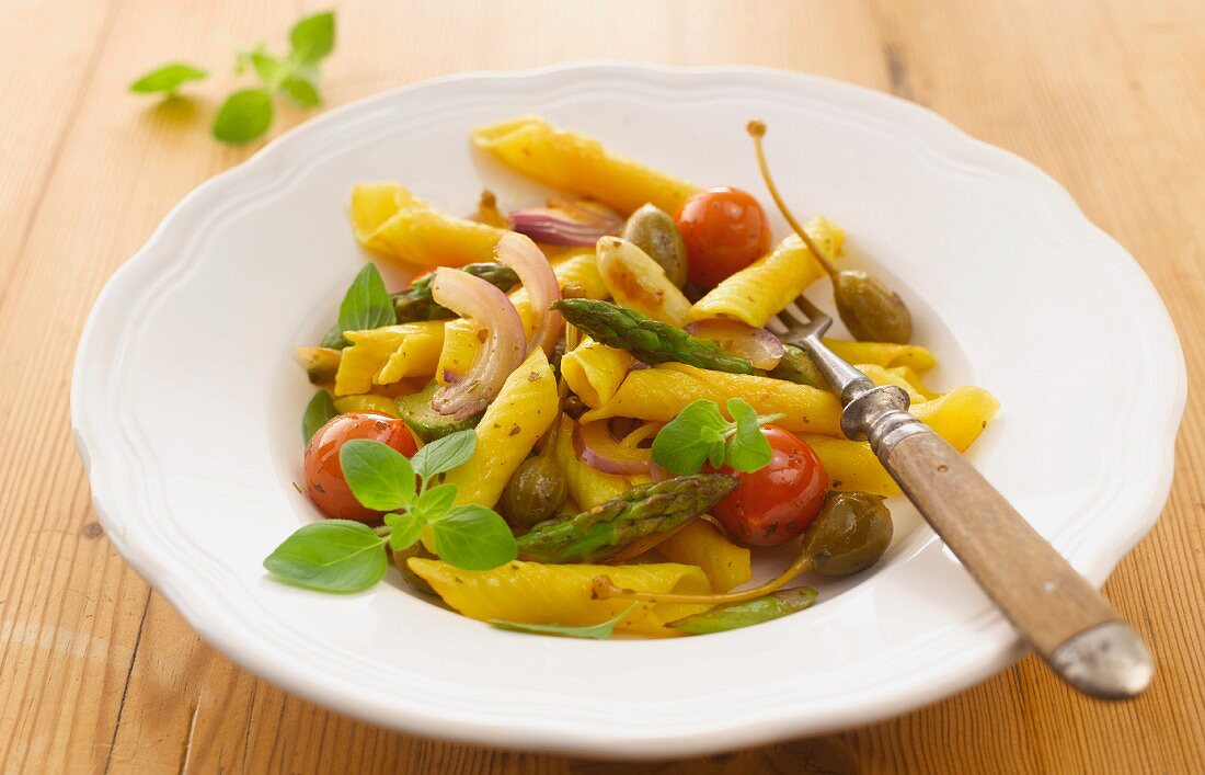 Pasta salad with asparagus, cherry tomatoes and giant capers