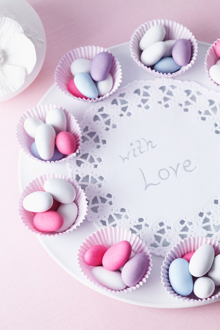 Sugared almonds in muffin cases on a plate with a message of love, for a wedding