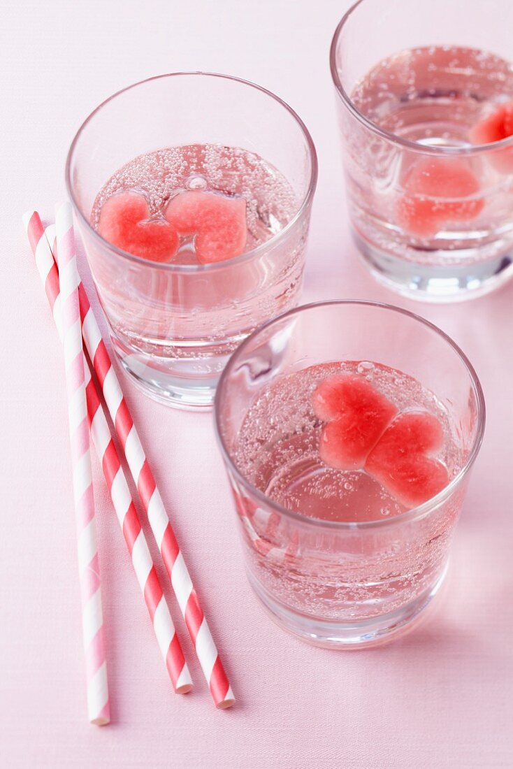 Water in glasses with heart-shaped ice cubes made from fruit juice