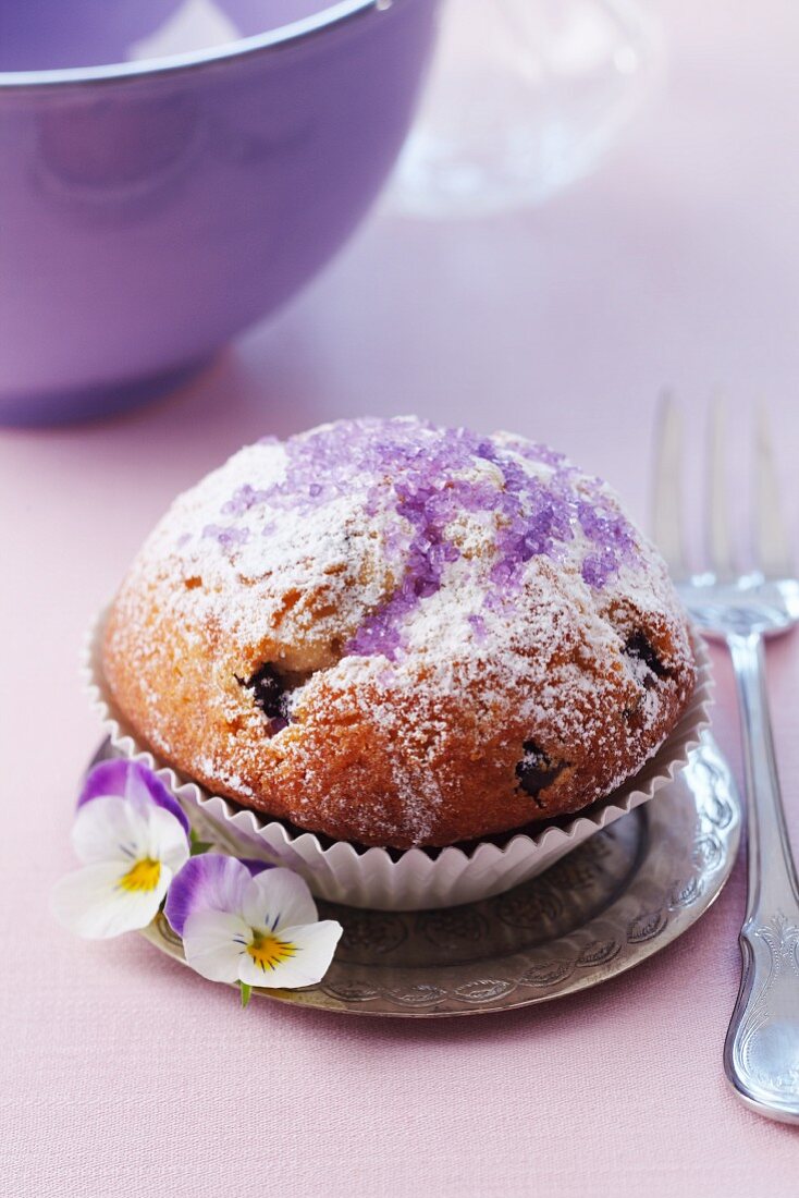 Muffin mit Puderzucker und lila Veilchenzucker