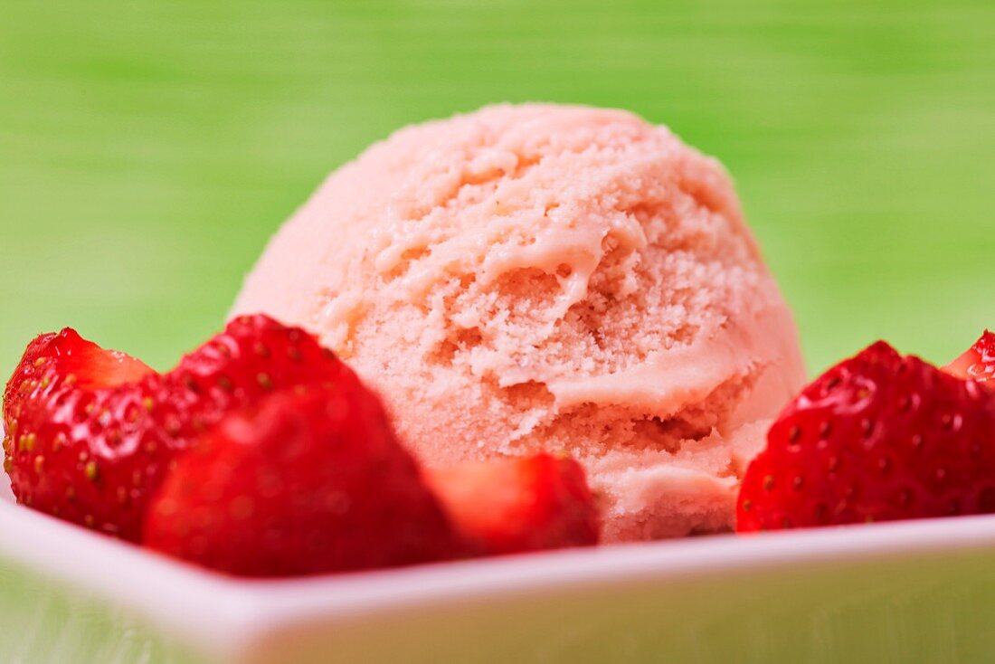 A scoop of strawberry ice cream with strawberry pieces