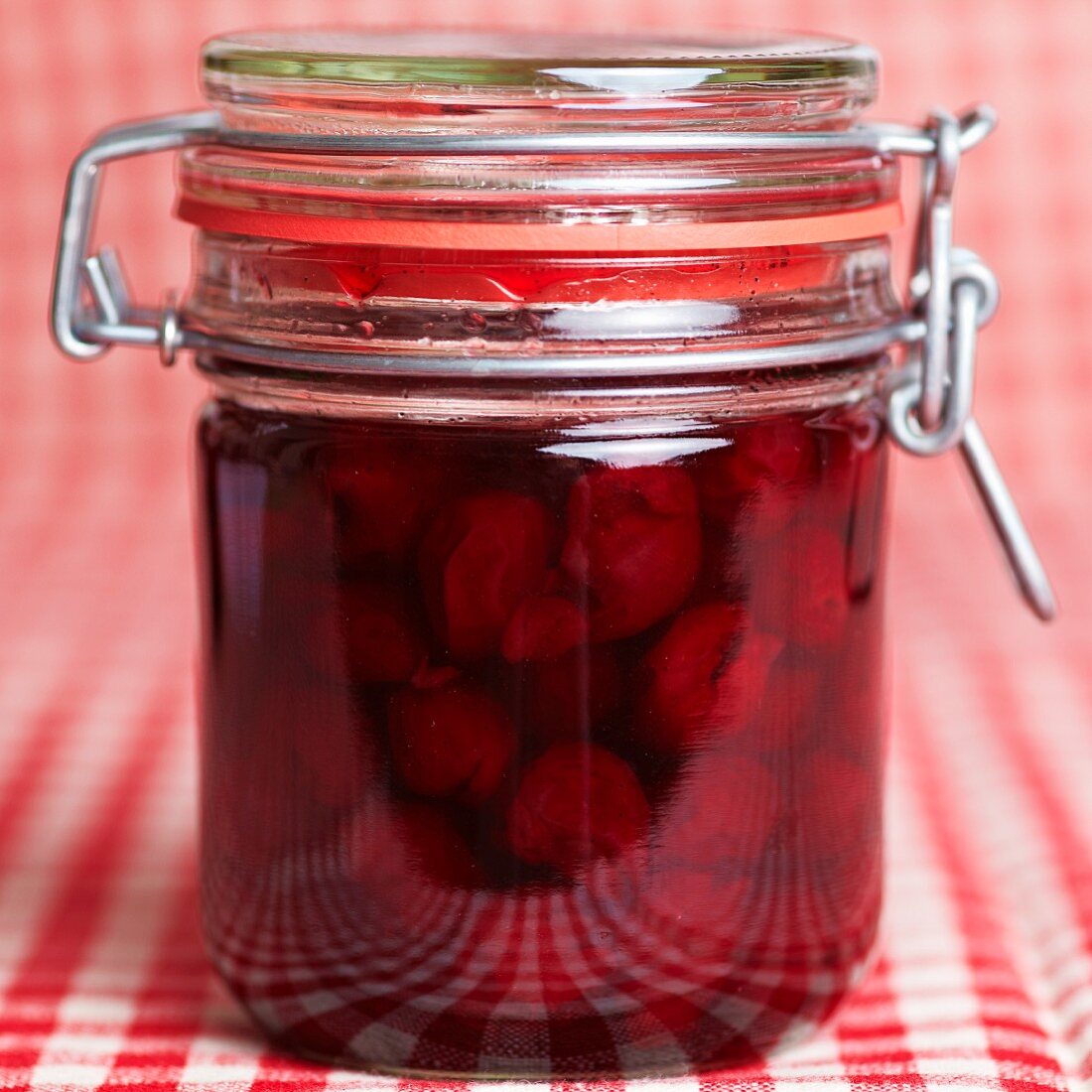 Preserved cherries as compote in a jar with a lever-closed top
