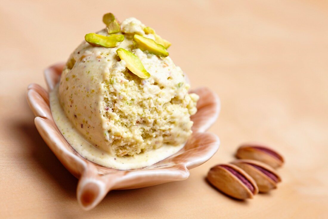 Home-made pistachio ice cream with pistachios as decoration, in a bowl