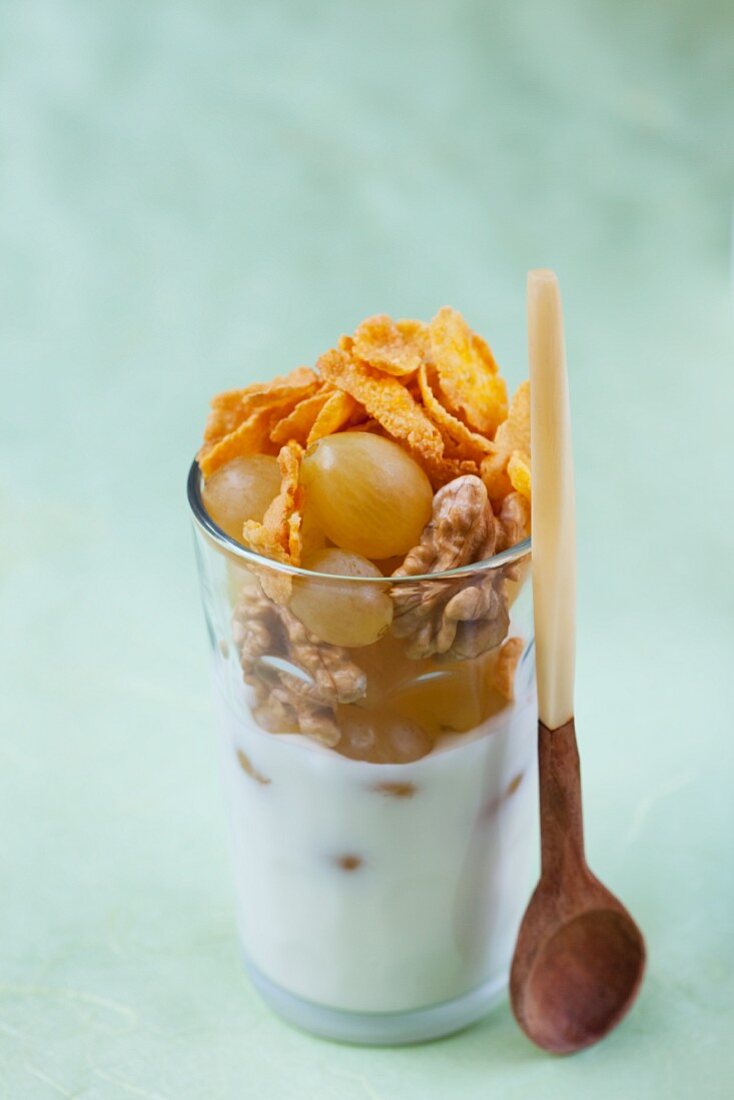 A layered dish of yoghurt, cornflakes and grapes
