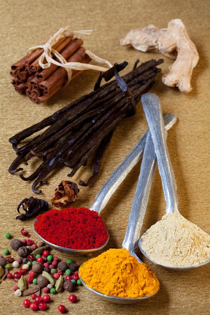Assorted spices, both whole spices and spoons full of ground spices