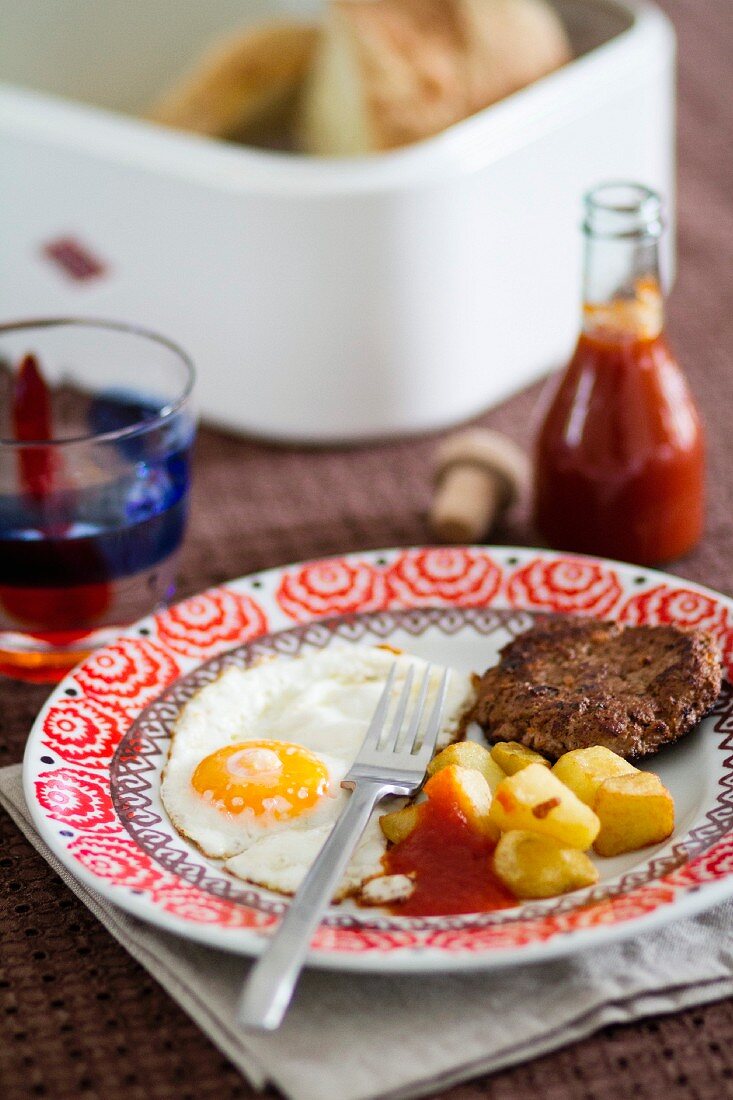 A fried egg, fried potatoes and Frikadelle (German burger), served with home-made ketchup