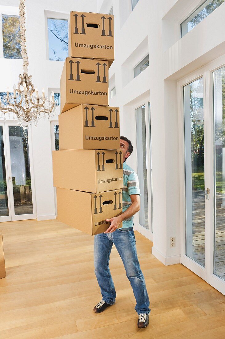 Man holding stack of packing boxes