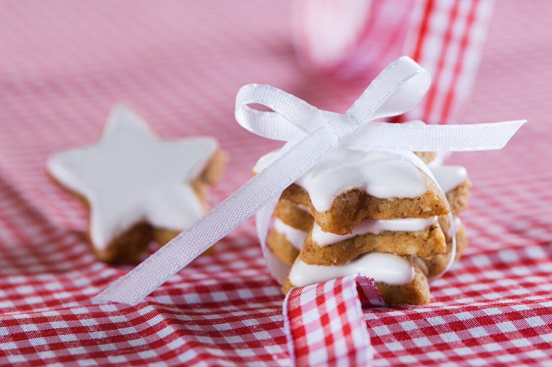 Star-shaped cinnamon biscuits on a gingham tablecloth decorated with a bow